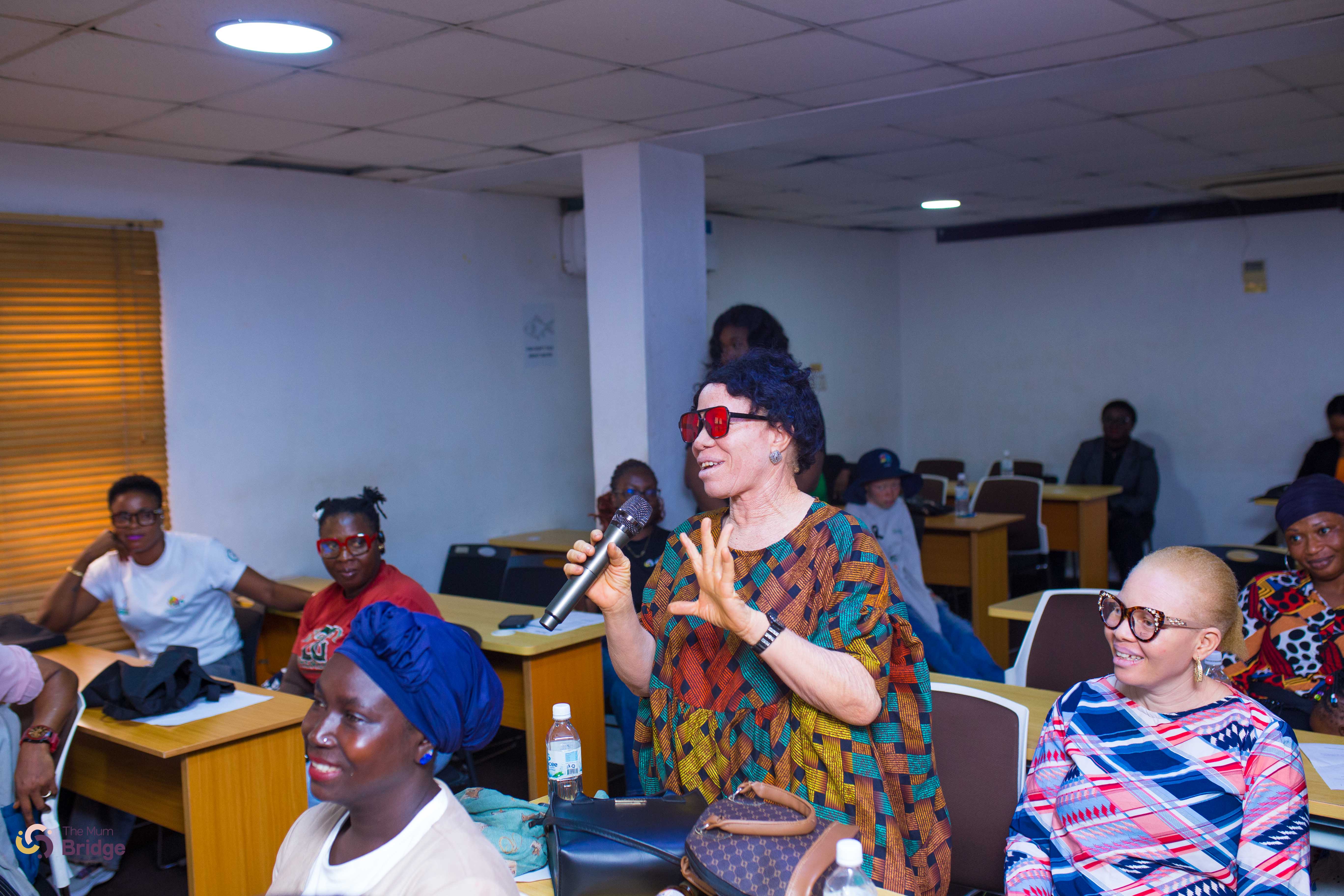 A community member speaks into a microphone, contributing to the Mum Bridge group dialogue