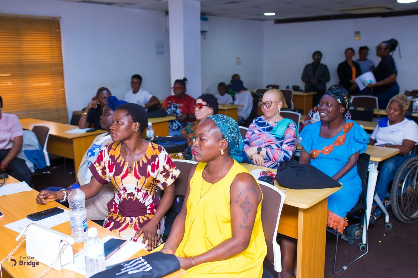 Mothers with disabilities seated together during a Mum Bridge community session, including a participant using a wheelchair