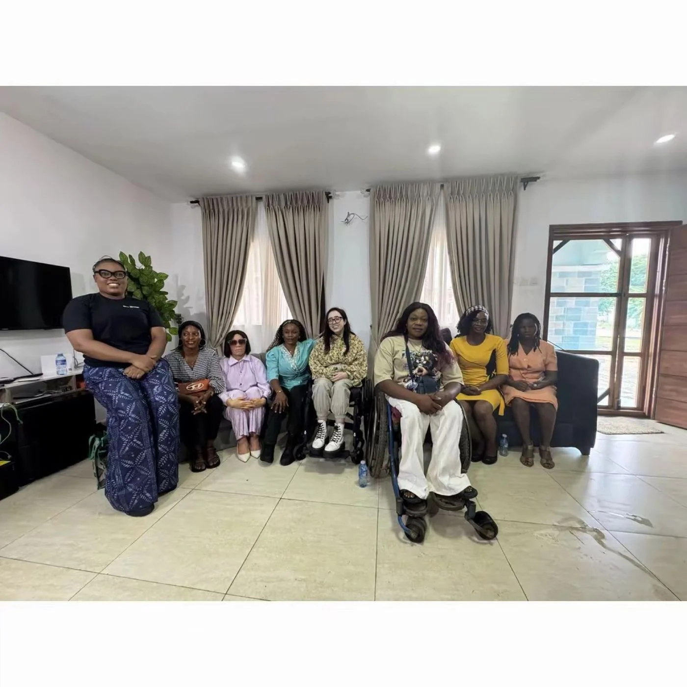 A wide view of the room during The Mum Bridge session with Niamh Ni Hoireabhaird, with participants seated in a semicircle and a wheelchair user at the centre